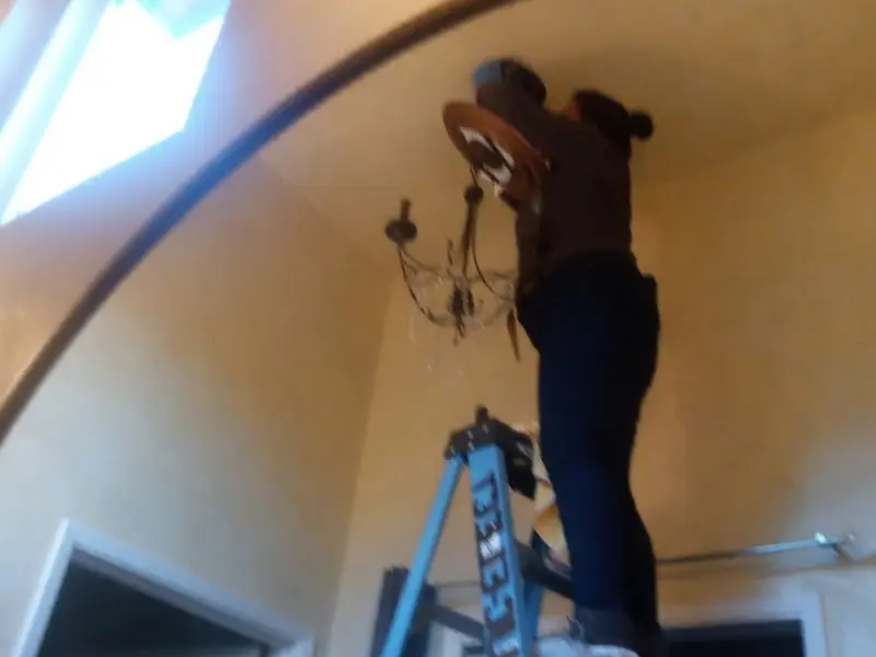 Electrician installing a chandelier in a Calhoun residence